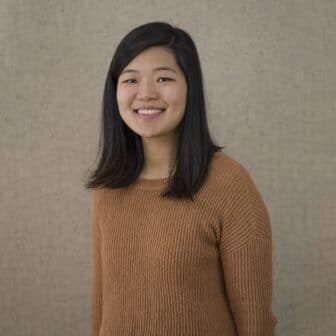 Cindy Lee smiling in front of grey/beige background