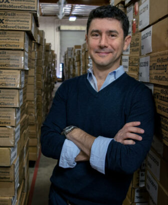 Jedd standing in front of boxes with arms crossed