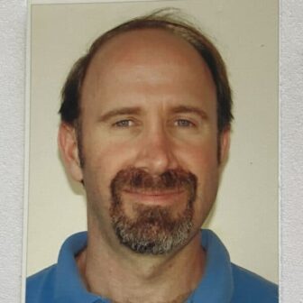 Neil smiling in front of white background